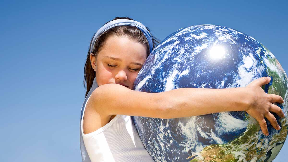 Niña abrazando planeta Tierra