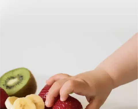 Mano de un niño tomando una fresa