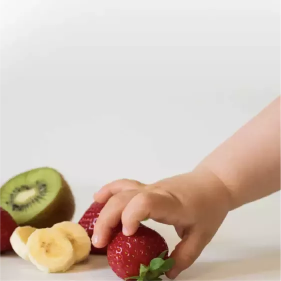 Mano de un niño tomando una fresa