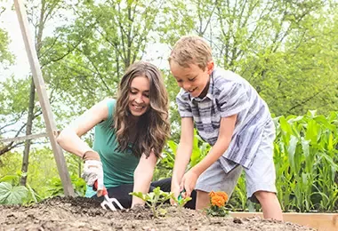 Madre e hijo plantando y cuidando medio ambiente